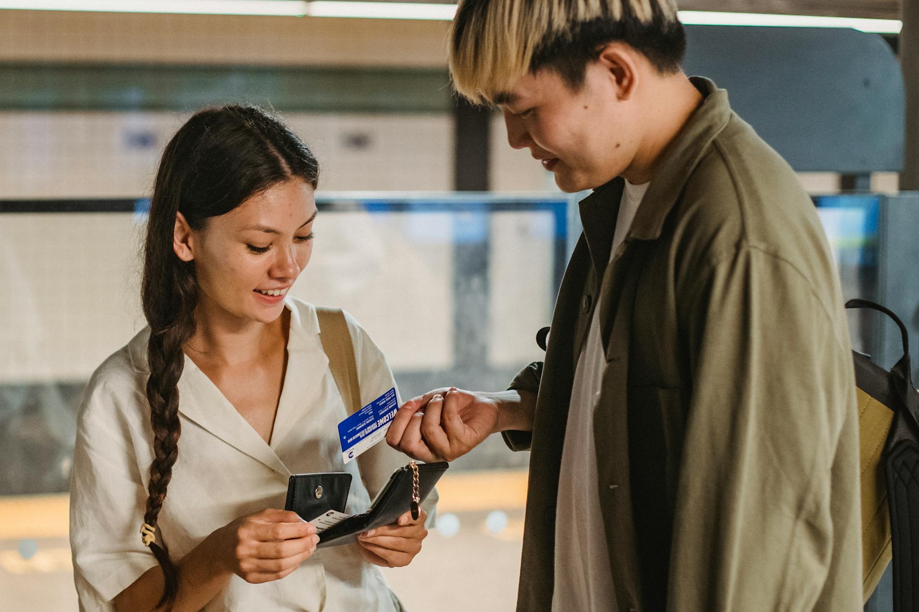 photo/positive-asian-couple-buying-subway-tickets-5225420/